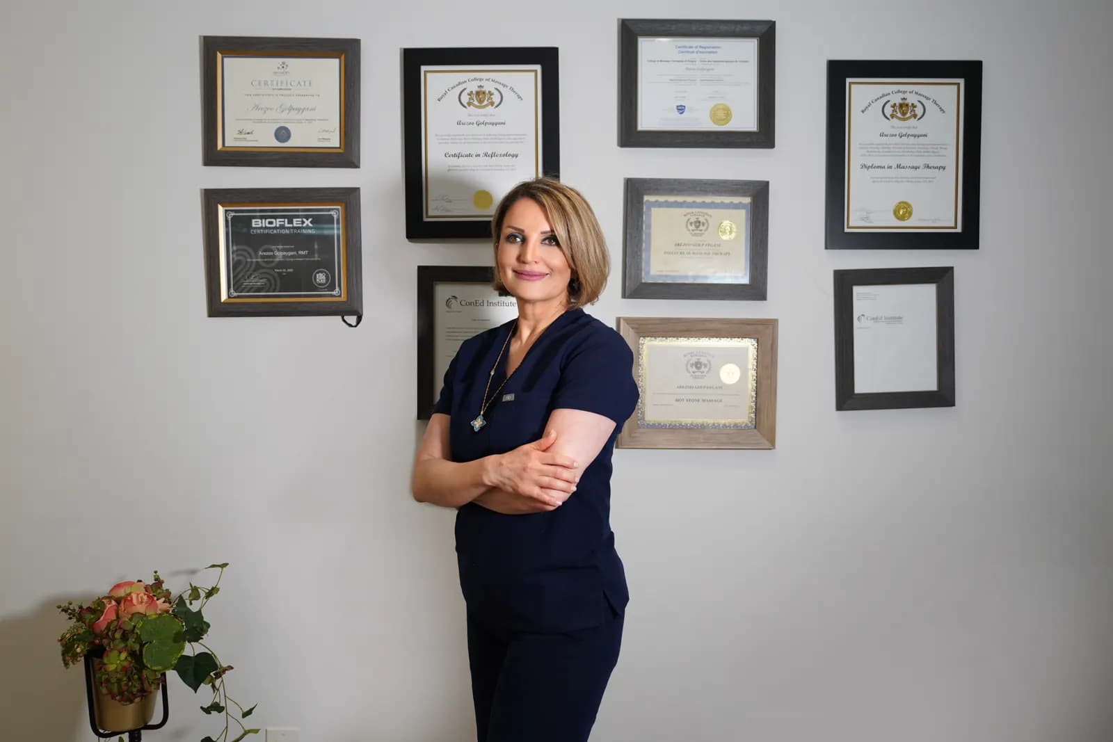 Arezoo (Rose) Golpayegani standing before her professional certifications