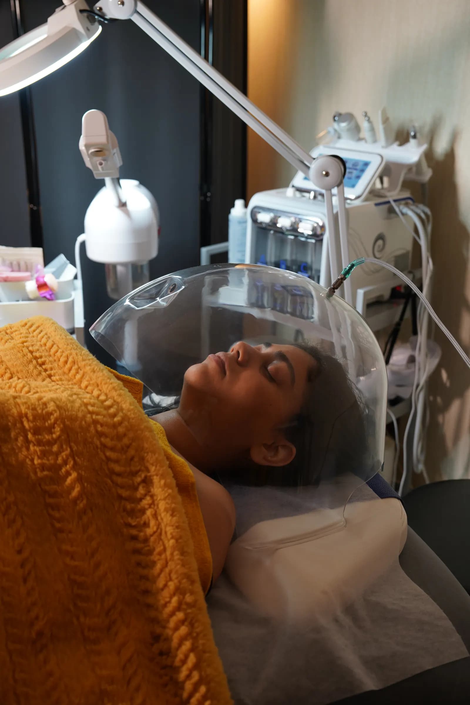 Oxygen dome facial treatment on relaxed client