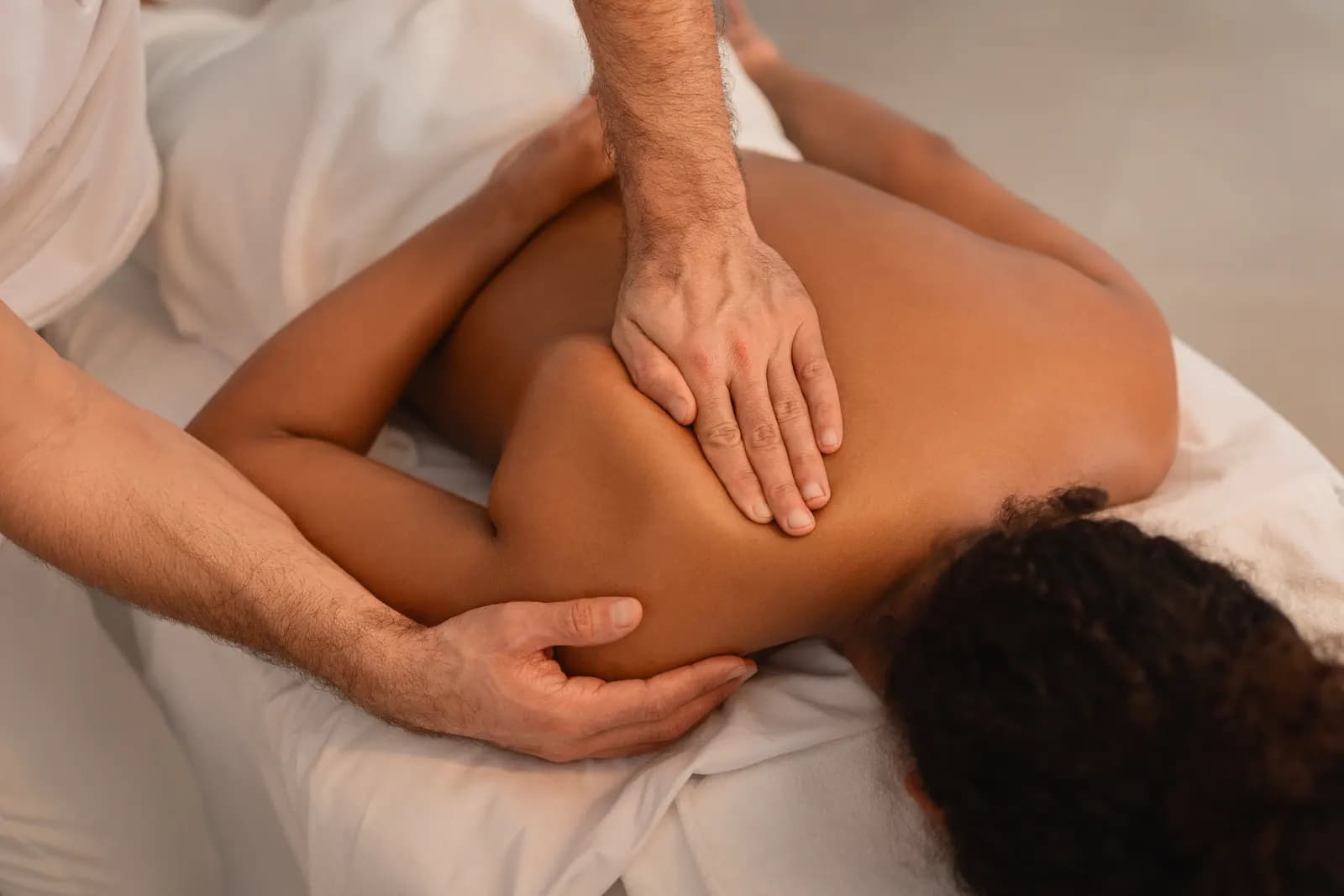 Therapeutic massage focused on the client's shoulder and upper back