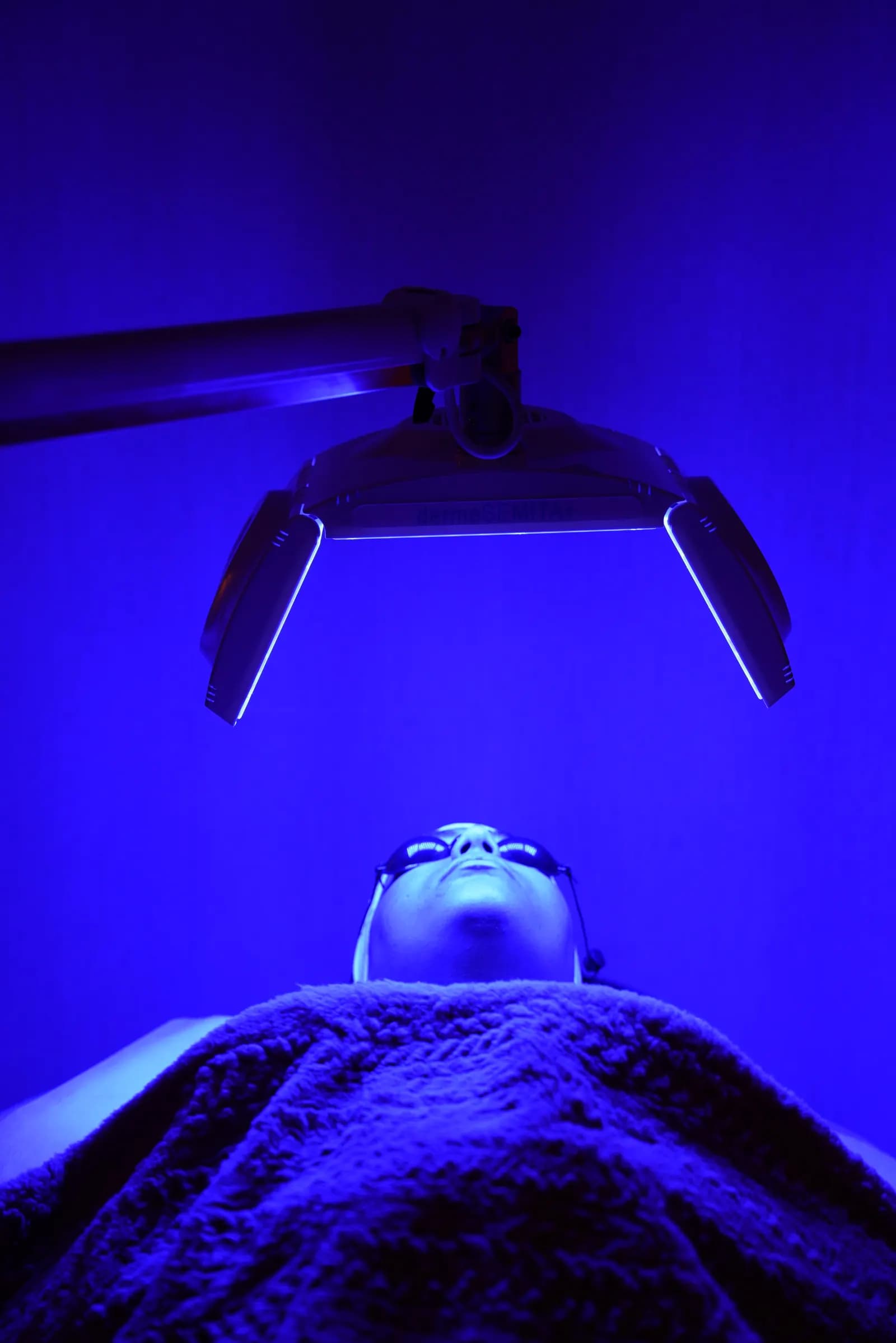 Blue LED light therapy panel positioned over the client's face
